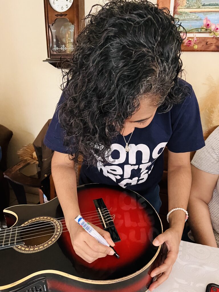 Liana firmando la guitarra de Edu